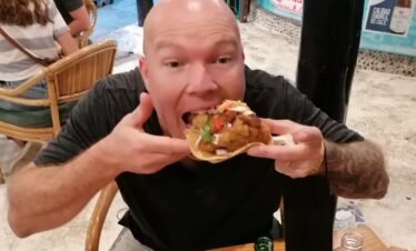 Traveler taking a bite of a street taco during a Cancun Taco Tour in downtown Cancun