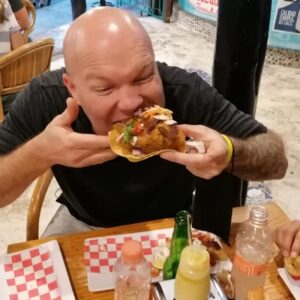 Traveler taking a bite of a street taco during a Cancun Taco Tour in downtown Cancun