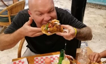 Traveler taking a bite of a street taco during a Cancun Taco Tour in downtown Cancun