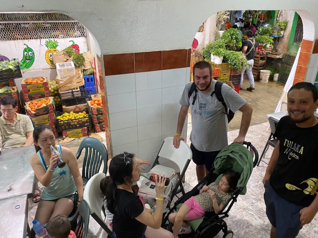 Family with strollers waiting for food at Mercado 23 Cancun local market