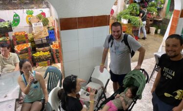 Family with strollers waiting for food at Mercado 23 Cancun local market
