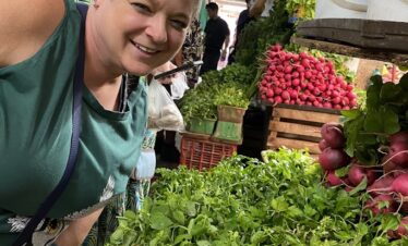 Traveler exploring fresh vegetables and aromatic herbs at Mercado 23 Cancun market