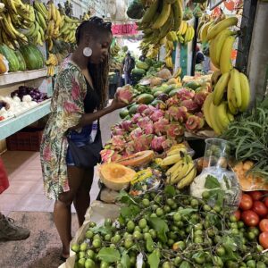 Traveler holding fresh dragon fruit (pitaya) at Mercado 23 local market in Cancun