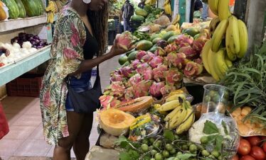 Traveler holding fresh dragon fruit (pitaya) at Mercado 23 local market in Cancun