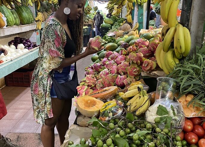 Traveler holding fresh dragon fruit (pitaya) at Mercado 23 local market in Cancun