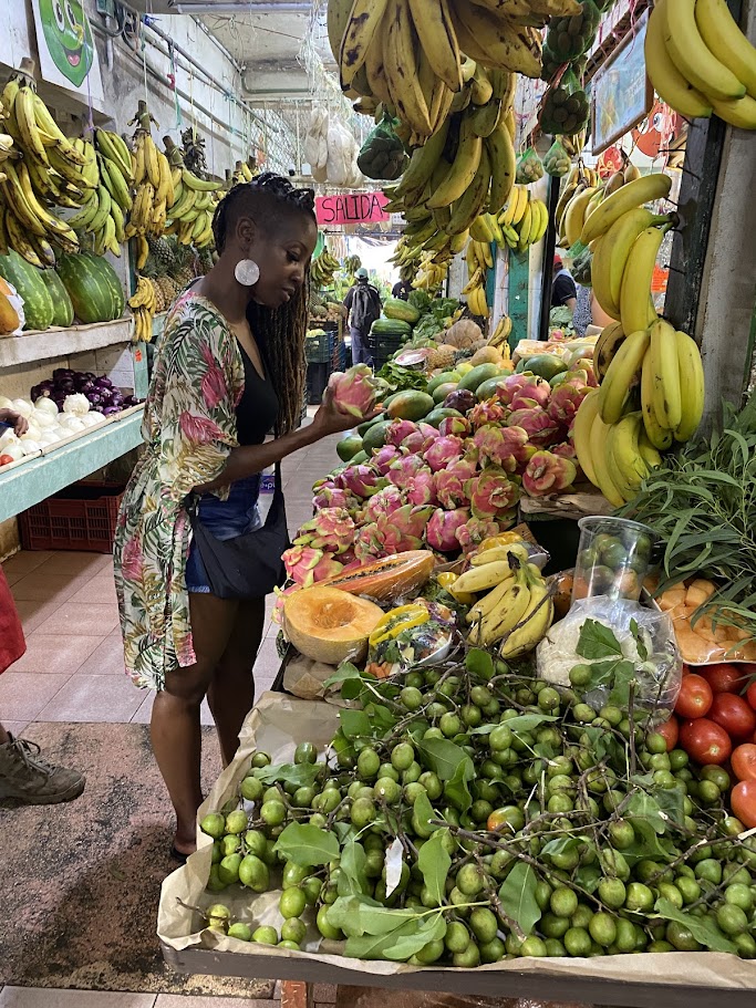 Traveler holding fresh dragon fruit (pitaya) at Mercado 23 local market in Cancun