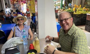 Couple enjoying traditional pork taco at Mercado 23 Cancun food market