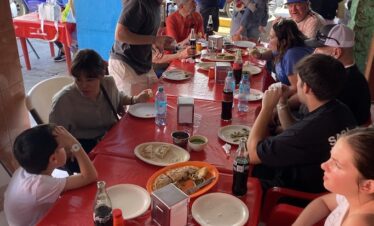 Large family enjoying gorditas and quesadillas at Mercado 23 Cancun food stalls