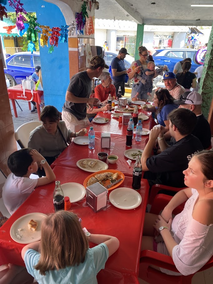 Large family enjoying gorditas and quesadillas at Mercado 23 Cancun food stalls
