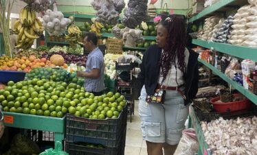 Traveler exploring fresh produce and spices inside Mercado 23 Cancun market