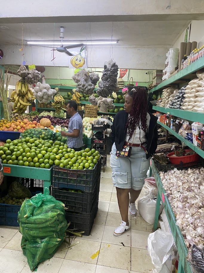 Traveler exploring fresh produce and spices inside Mercado 23 Cancun market