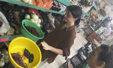 Travelers choosing dried chiles at Mercado 23 local market in Cancun