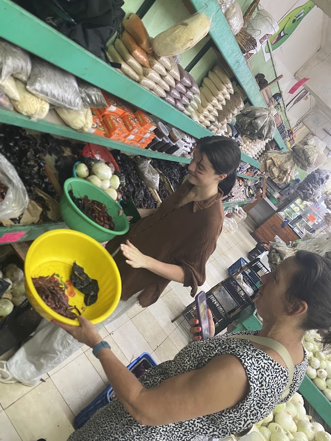 Travelers choosing dried chiles at Mercado 23 local market in Cancun