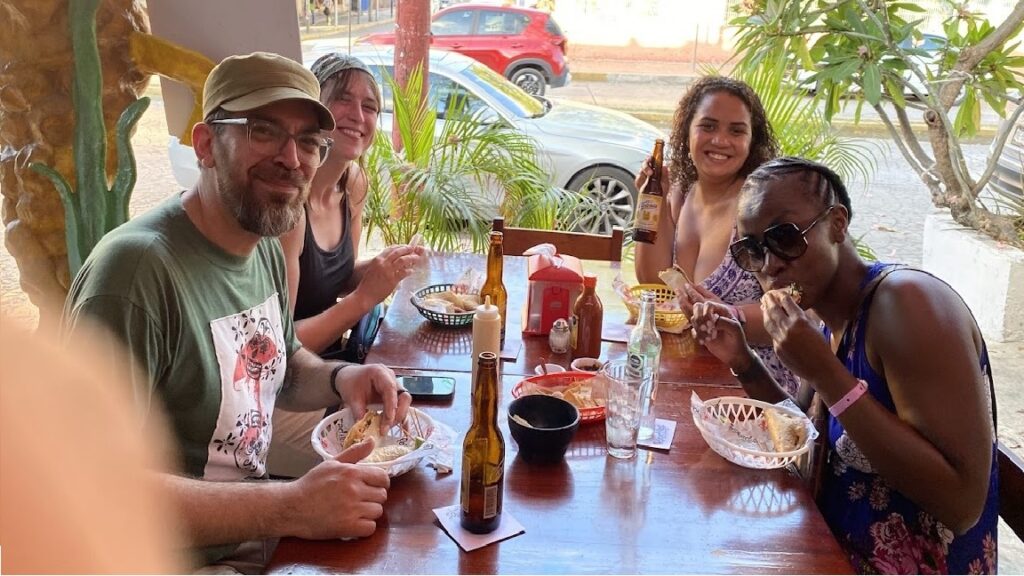 Travelers enjoying fish tacos and hard shell shrimp tacos during a Cancun Taco Tour