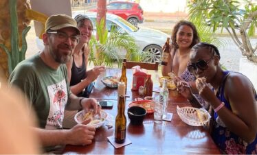 Travelers enjoying fish tacos and hard shell shrimp tacos during a Cancun Taco Tour