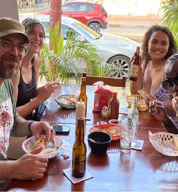 Travelers enjoying fish tacos and hard shell shrimp tacos during a Cancun Taco Tour