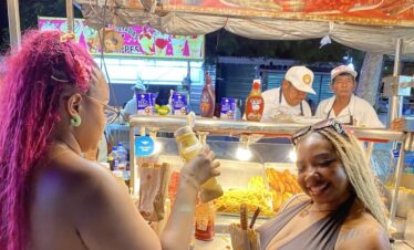 Two travelers enjoying fresh churros at the end of a Cancun Taco Tour
