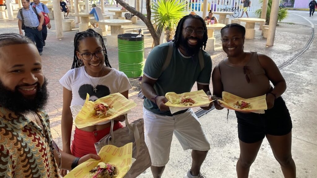 Travelers holding a plate of Yucatecan salbutes during a Cancun Taco Tour