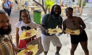 Travelers holding a plate of Yucatecan salbutes during a Cancun Taco Tour