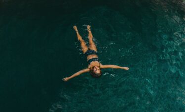 Woman floating in cenote water surrounded by nature Riviera Maya experience