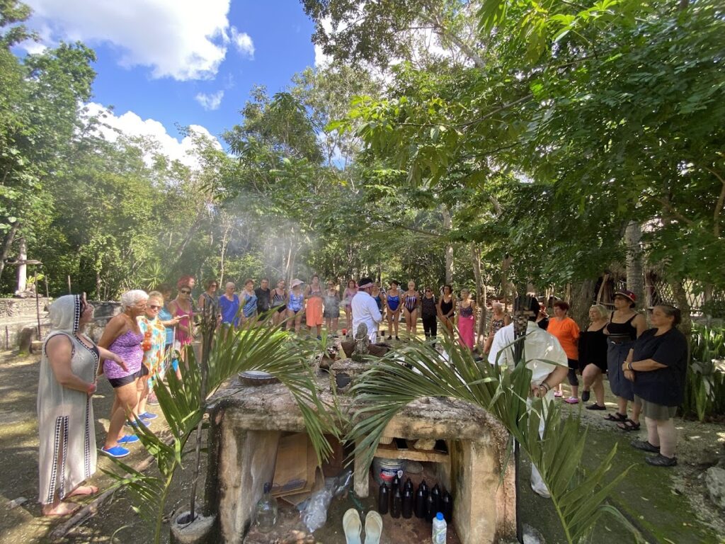Mayan spiritual guide blessing participants in semicircle before temazcal ceremony in Riviera Maya